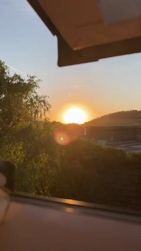 Partial solar eclipse plays out against a warm sunset sky