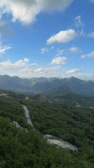 Man observes mountain valley from bridge in Montenegro