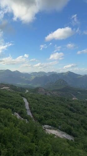 Man observes mountain valley from bridge in Montenegro