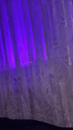 Purple-lit patterned curtain observed in Bender, Moldova window