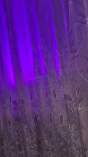 Purple-lit patterned curtain observed in Bender, Moldova window