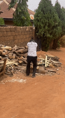 Man chops wood outdoors in Jos, Nigeria