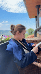 Woman reads document on balcony in Balaklava district
