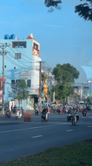 Traffic light turns green, motorcycles proceed in Thuận An