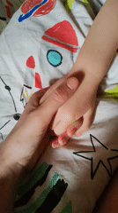 Hands clasp over space-themed fabric in Ust-Ilimsk, Russia