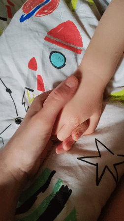 Hands clasp over space-themed fabric in Ust-Ilimsk, Russia