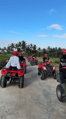 ATV group tours Indonesian countryside paths in matching red gear