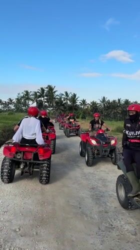 ATV group tours Indonesian countryside paths in matching red gear