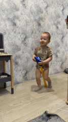 Toddler plays with pogo stick indoors in Rusanovo