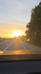 Driver captures sunset view on tree-lined road near Birobidzhan