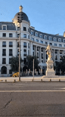 Stone statue outside grand domed building in Bucharest