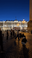 Street musician performs in St. Petersburg's Palace Square at dusk
