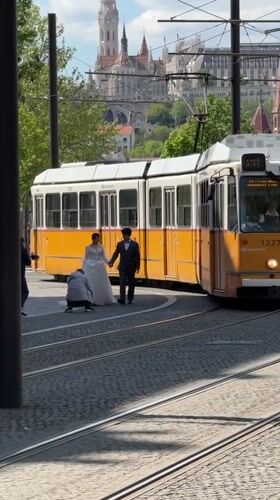 Wedding photoshoot takes place on Budapest street with tram rails