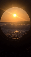 Sunset on a Soroni beach, framed through tires and cairns.