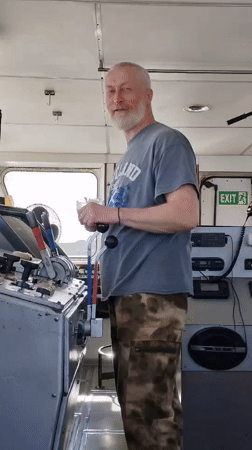 Man with wine observed in boat control room, Topornya