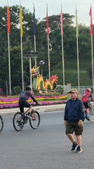 Evening street activity observed near dragon sculpture in Da Lat
