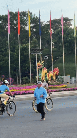 Evening street activity observed near dragon sculpture in Da Lat