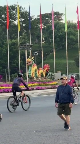 Evening street activity observed near dragon sculpture in Da Lat