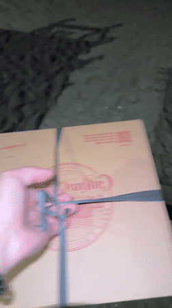 Person holds cardboard box on North Kuta beach