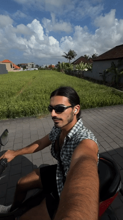 Man rides scooter past rice paddies in North Kuta