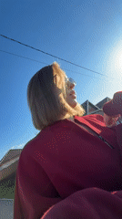 Woman applies makeup outdoors in Reshetnikovo spring afternoon