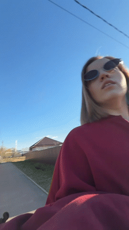 Woman applies makeup outdoors in Reshetnikovo spring afternoon