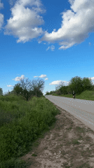 Cyclist travels rural road under cloudy skies in Perushtitsa