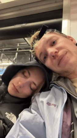 Woman sleeps on companion's shoulder during train ride