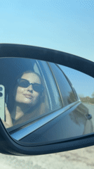 Woman with sunglasses uses phone in moving car near Polozovo