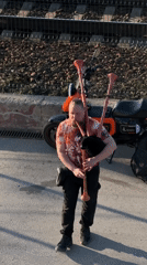 Bagpiper performs, tourists take selfies along Kama River in Perm