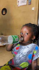 Girl drinks water from bottle in Kuru Dungus Nigeria