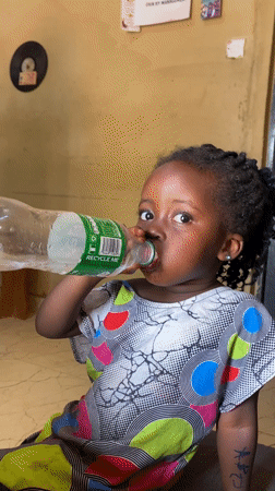 Girl drinks water from bottle in Kuru Dungus Nigeria