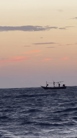 Fishing boat crosses choppy Ko Samui waters at dawn