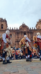 Traditional masked performers gather in public square ceremony