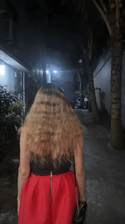 Woman walks through narrow alleyway in North Kuta, Indonesia