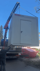 Crane truck lifts white cabin in Munich