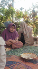 Outdoor meal gathering with cat in Tanjongputoh, Indonesia
