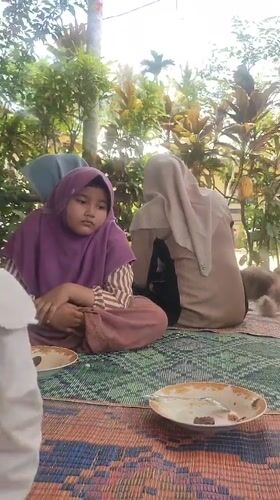 Outdoor meal gathering with cat in Tanjongputoh, Indonesia