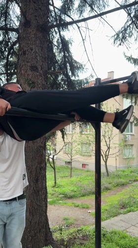 Two men interact outdoors in Berkovitsa, Bulgaria