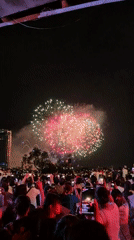 Nighttime fireworks draw a crowd with phones out
