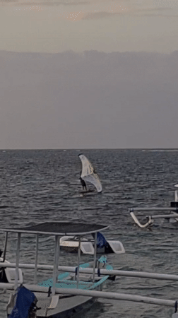 Sunset at a Bali beach — boats, wing foiling, and local life