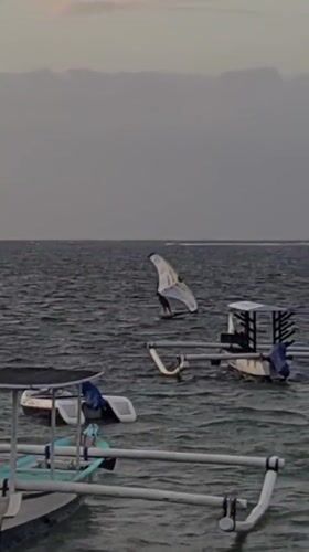 Sunset at a Bali beach — boats, wing foiling, and local life