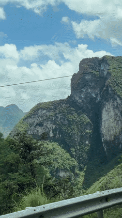 Traveler documents rural Vietnamese mountain landscapes from moving vehicle