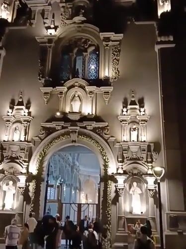 Illuminated church facade observed at night in Miraflores, Peru