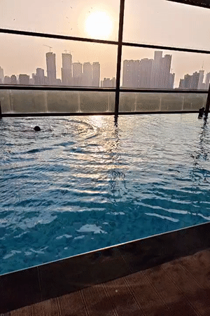 Rooftop pool swim captured against Mumbai sunset skyline