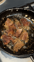 Meat chunks frying in pan captured on video