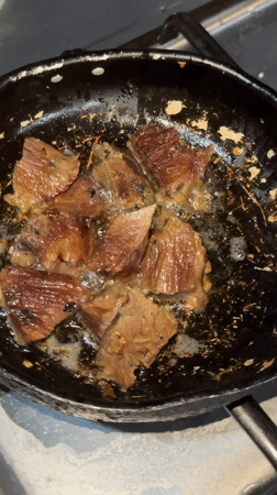 Meat chunks frying in pan captured on video