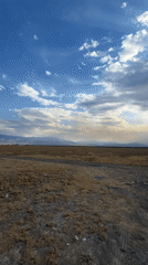 Sun breaking through clouds over Kazakhstan's dry steppe