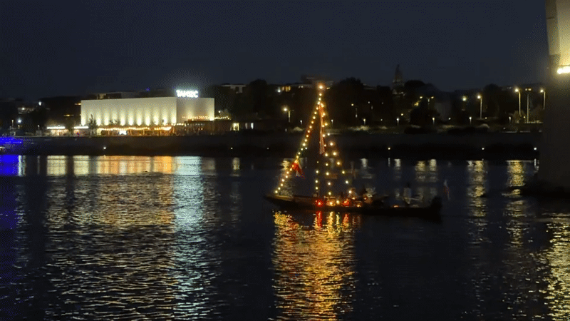 Festive sailboat drifts the Vistula under Warsaw's lit skyline