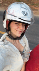 Woman smiles during motorcycle ride in Mũi Né, Vietnam